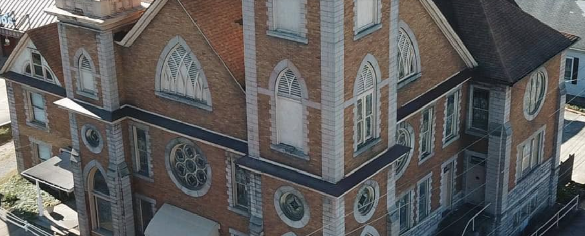 Close aerial view of the church's arched windows, brickwork, and stonework
